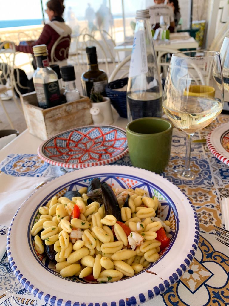 Eating seafood pasta on the coast in Puglia, Italy